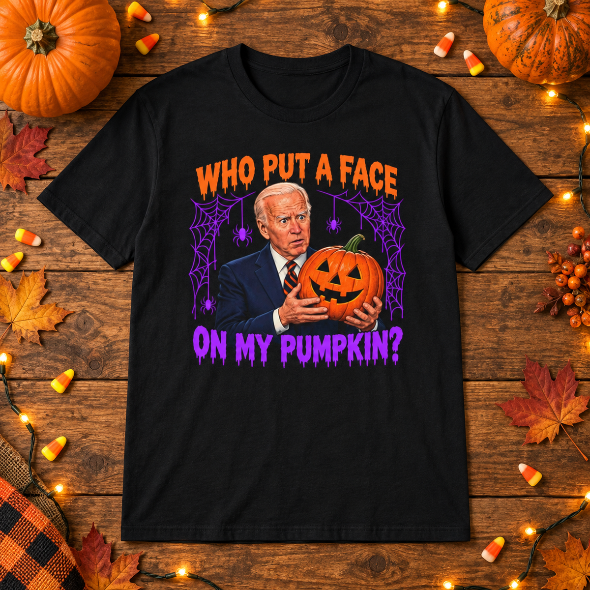 Black Who Put a Face on My Pumpkin shirt styled with pumpkins and candy corn on a wooden table.