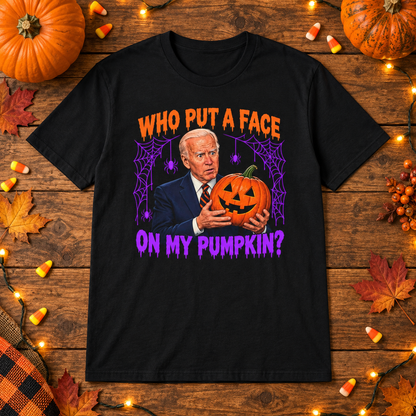 Black Who Put a Face on My Pumpkin shirt styled with pumpkins and candy corn on a wooden table.