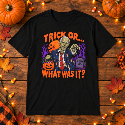 Black Joe Biden zombie trick or shirt on a wooden background with Halloween lights, pumpkins and candy